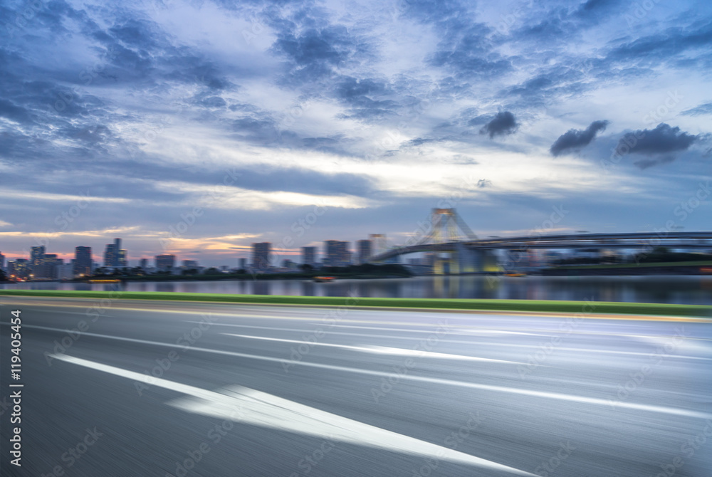 cityscape and skyline of tokyo at sunset from empty road