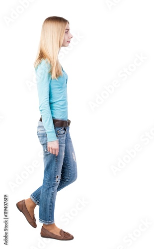 side view of walking woman in jeans. beautiful blonde girl in motion. backside view of person. Rear view people collection. Isolated over white background. Girl in leather shoes are left