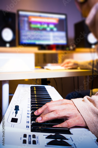 asian arranger hands working on keyboards in recording studio for music production concept