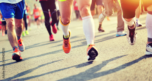 Unidentified marathon athletes legs running on city road