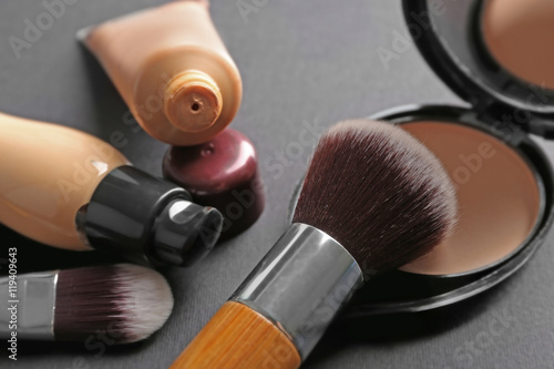 Make up brushes and foundation on grey background