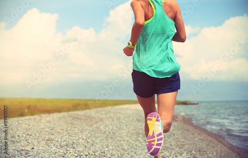 healthy young fitness woman trail runner running on seaside