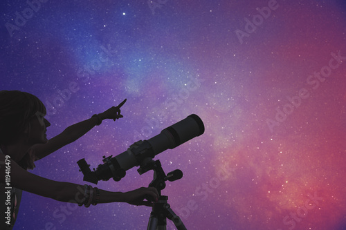 Girl looking at the stars with telescope beside her.  © astrosystem