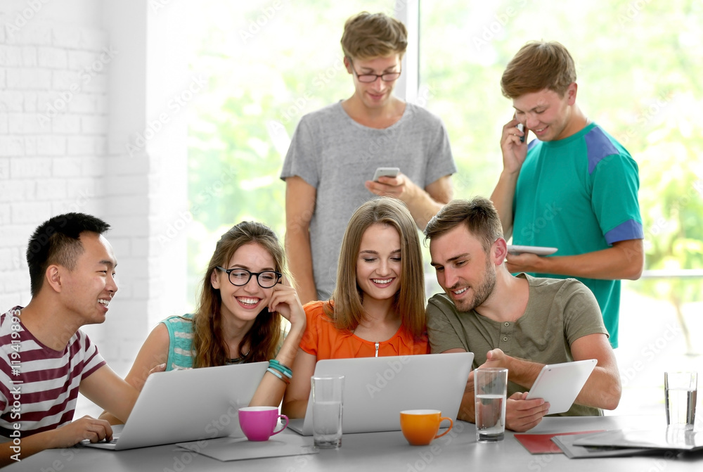 Young people with gadgets hanging out together