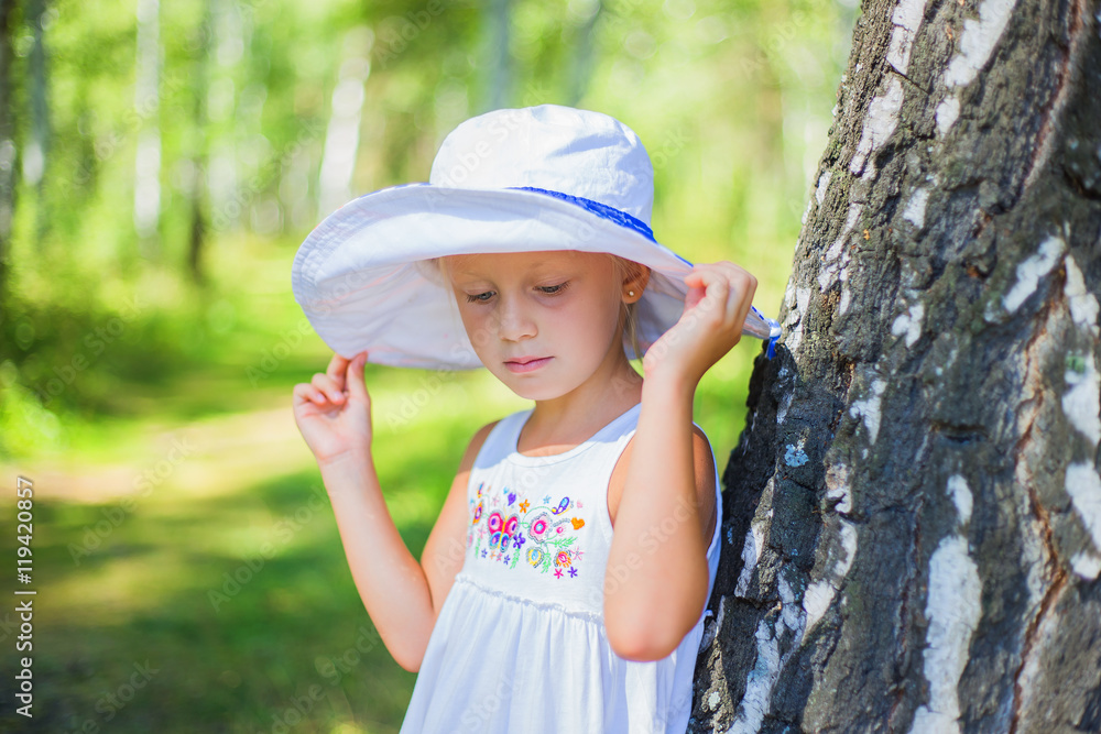 portrait of a beautiful girl in a white hat summer day in the park