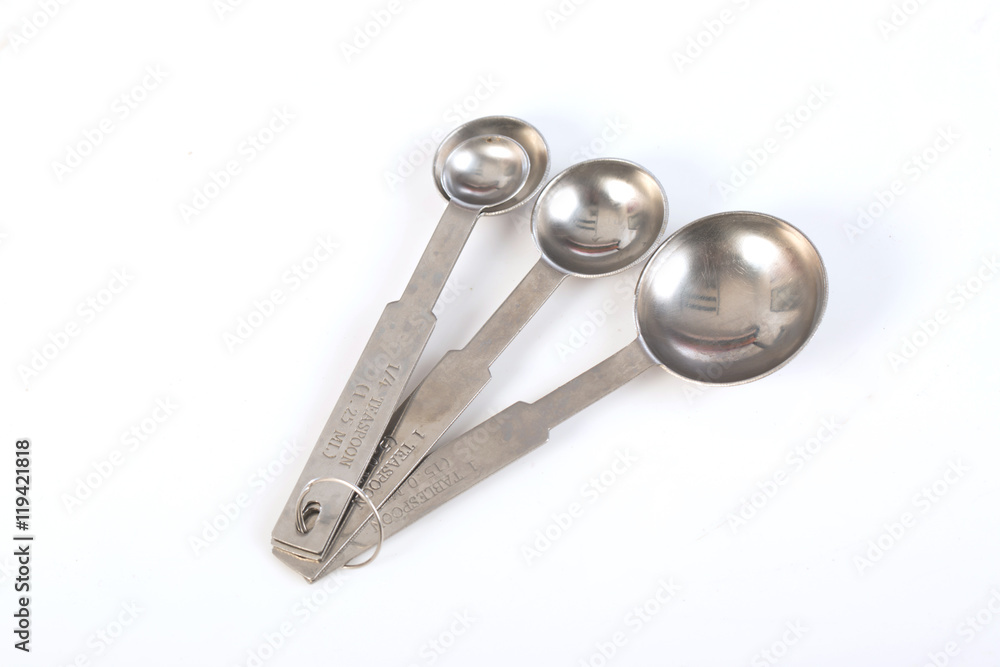 Steel measuring spoons on white background,selective focus Steel measuring spoons on white background,selective focus