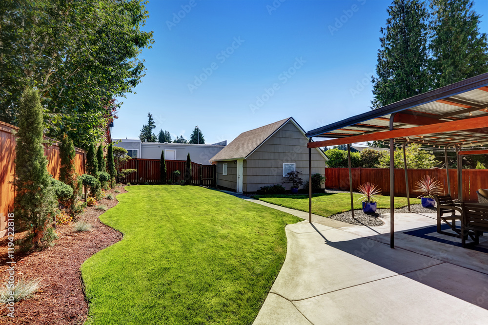 Backyard area with garage and perfectly trimmed garden.
