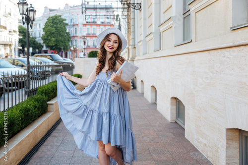 Photography Happy woman in hat and blue dress in the city
