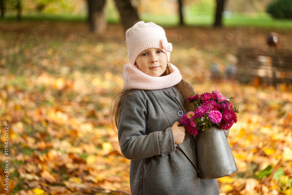 Young girl with autumn bouquet in a watering pot