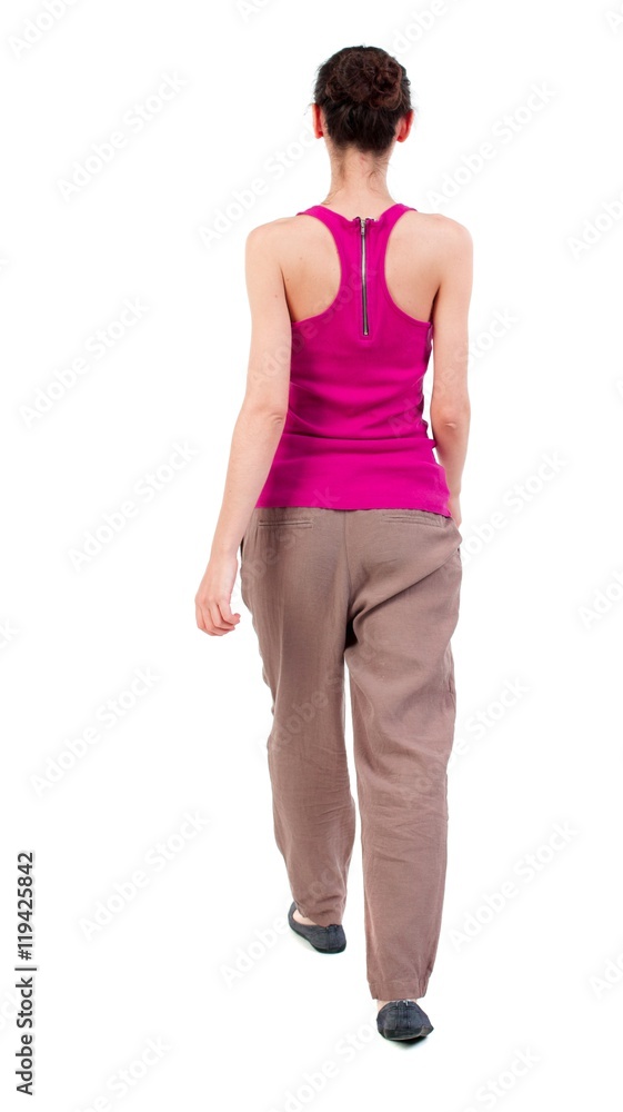 back view of walking curly woman. dark-skinned girl in a red shirt goes the distance. back view of walking curly woman. dark-skinned girl in a red shirt goes the distance.