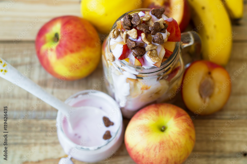 Slices of apple, peach, nectarine, plum and banana blended with yogurt and chocolate corn flakes on wooden table, top view Slices of apple, peach, nectarine, plum and banana blended with yogurt and chocolate corn flakes on wooden table, top view