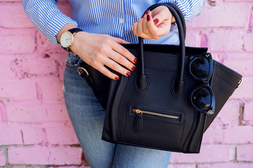 Leinwandbilder Nagelstudio Schwarze Lederhandtasche in Modefrauenhand  © visoook