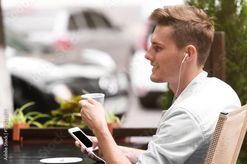 Handsome man listening musi...