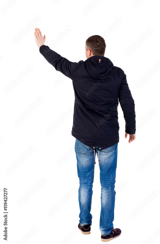 Back view of beautiful man welcomes. man hand waving from. Rear view people collection. Man in warm jacket waving his right hand in greeting. Back view of beautiful man welcomes. man hand waving from. Rear view people collection. Man in warm jacket waving his right hand in greeting.