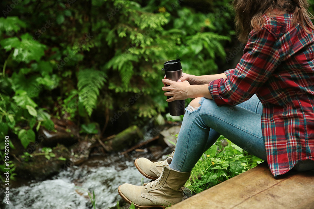 Girl relaxing with drink in forest Girl relaxing with drink in forest