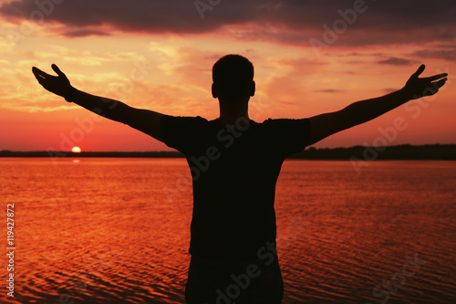 Silhouette of man on sunset sky background © Africa Studio
