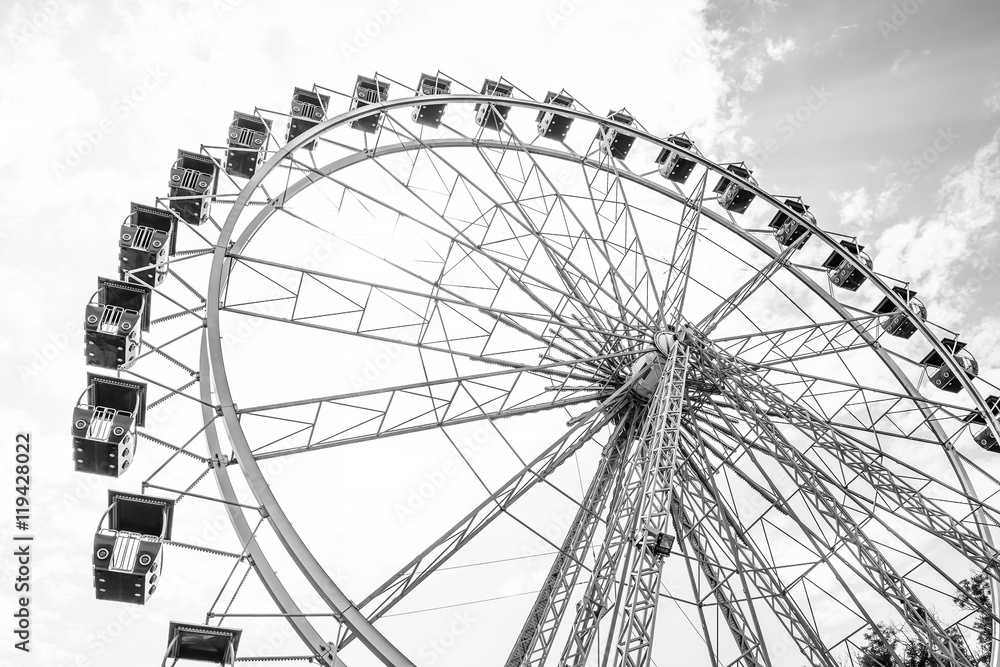 The Ferris wheel on the background of the cloudy sky