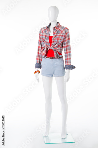 Mannequin in denim shorts and a checkered shirt. © margostock