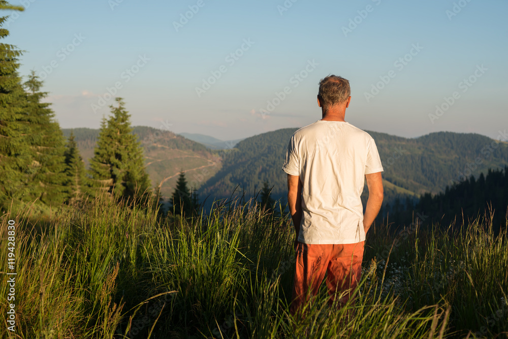 Man stands on a mountain meadow