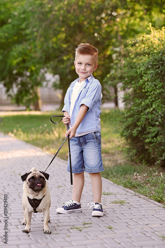 Cute boy with pug dog in park