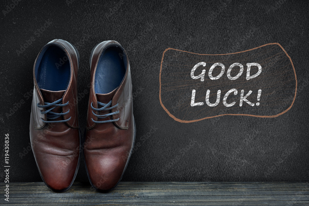 Good luck text on black board and business shoes Good luck text on black board and business shoes