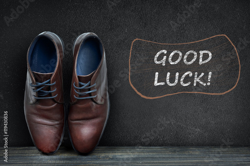 Good luck text on black board and business shoes