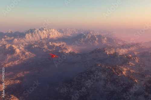 Misty snow mountains in morning mist with airplane flying over