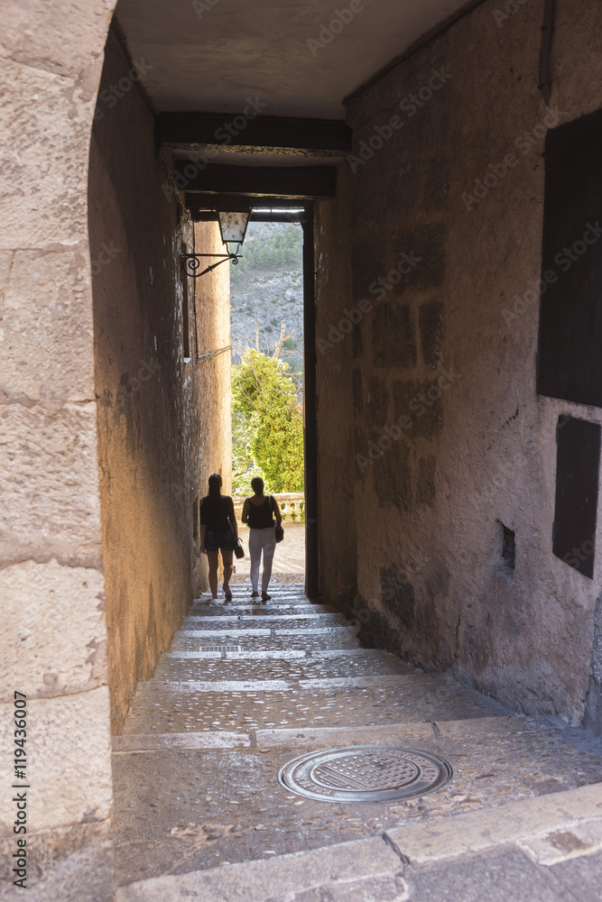 Tourists walk along the alleys close to the cathedral of Cuenca, Spain