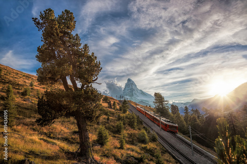 Matterhorn peak with a train against sunset in Swiss Alps, Switzerland photo