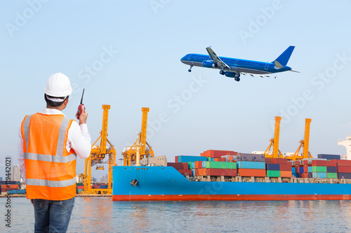 Dock worker talking with radio for controlling loading container