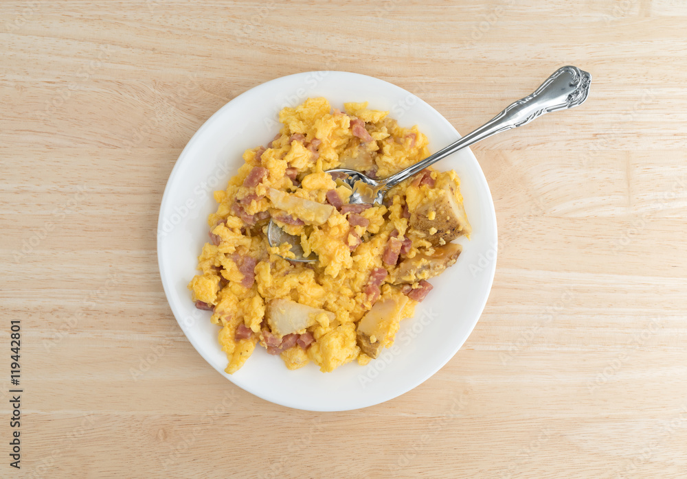 Ham eggs and potatoes breakfast TV dinner on a plate atop a wood table. Ham eggs and potatoes breakfast TV dinner on a plate atop a wood table.