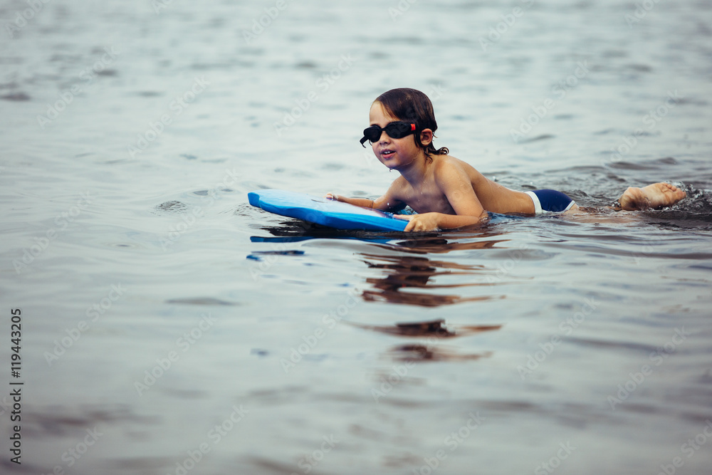 Smiling boy on bodyboard in water