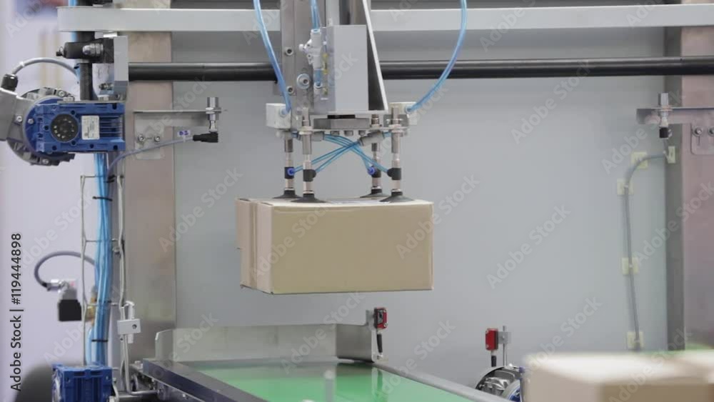 Shipping Box at Conveyor Belt With Handle Arm in Distribution Warehouse Shipping Box at Conveyor Belt With Handle Arm in Distribution Warehouse