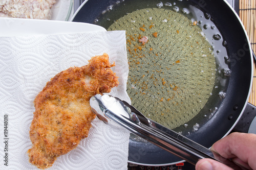 Chef keeping deep fried pork from pan photo