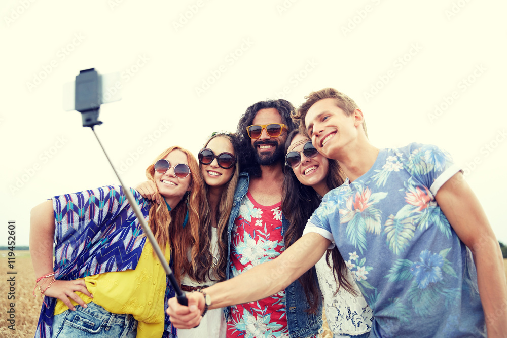 hippie friends with smartphone on selfie stick hippie friends with smartphone on selfie stick