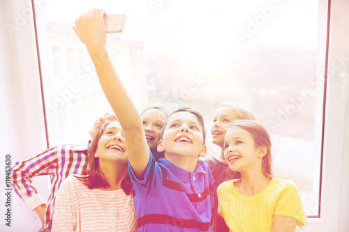 group of school kids taking selfie with smartphone