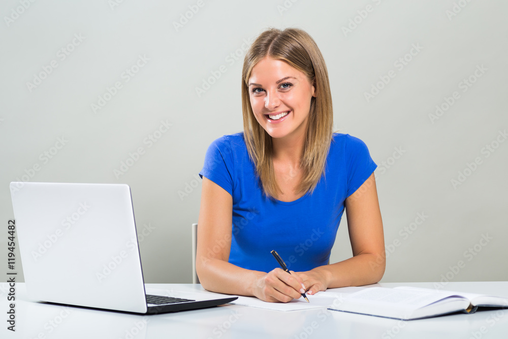Beautiful female student using laptop and studying.
Beautiful female student using laptop and studying.