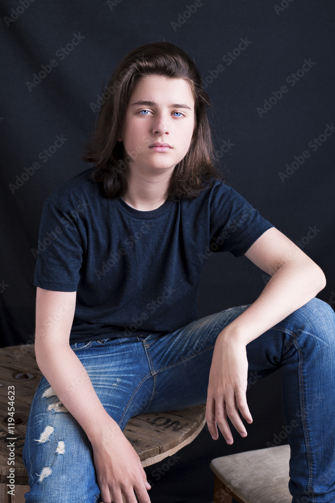 Fashion portrait of a handsome teenager on dark background Fashion portrait of a handsome teenager on dark background