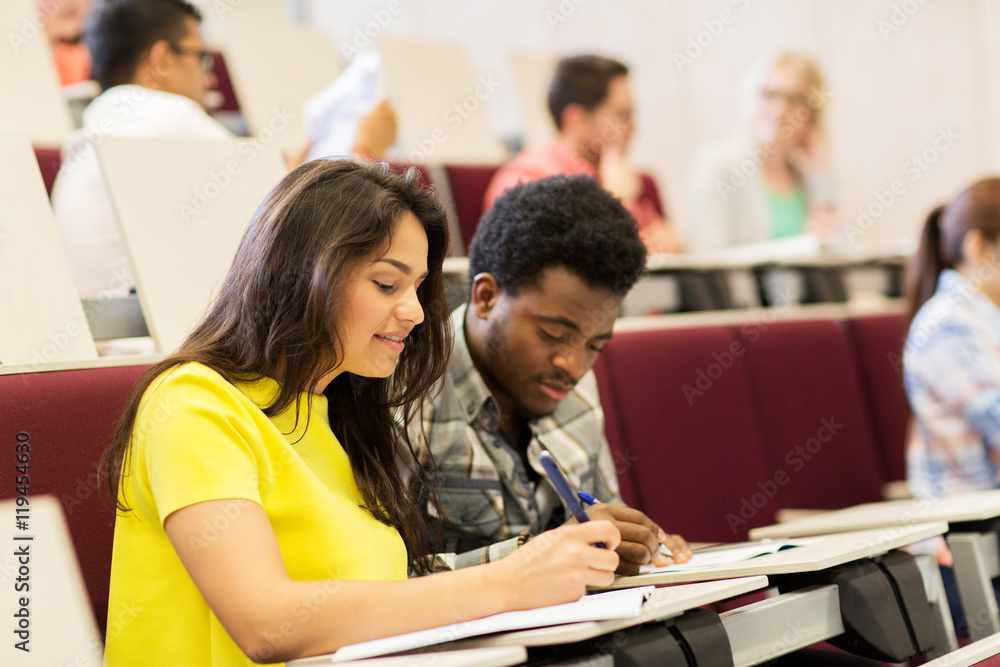 group of students with notebooks in lecture hall group of students with notebooks in lecture hall