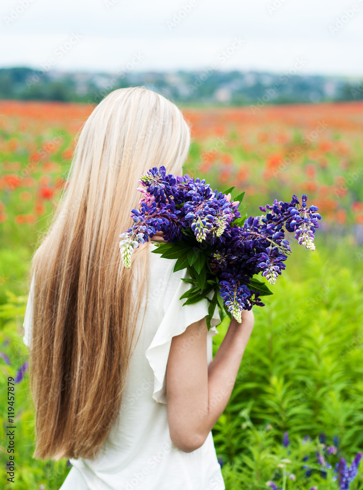 Fototapeta premium girl with bouquet of lupine flowers
