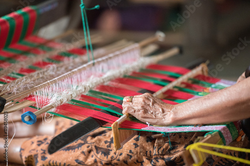 фотографія woman hand working at loom close up