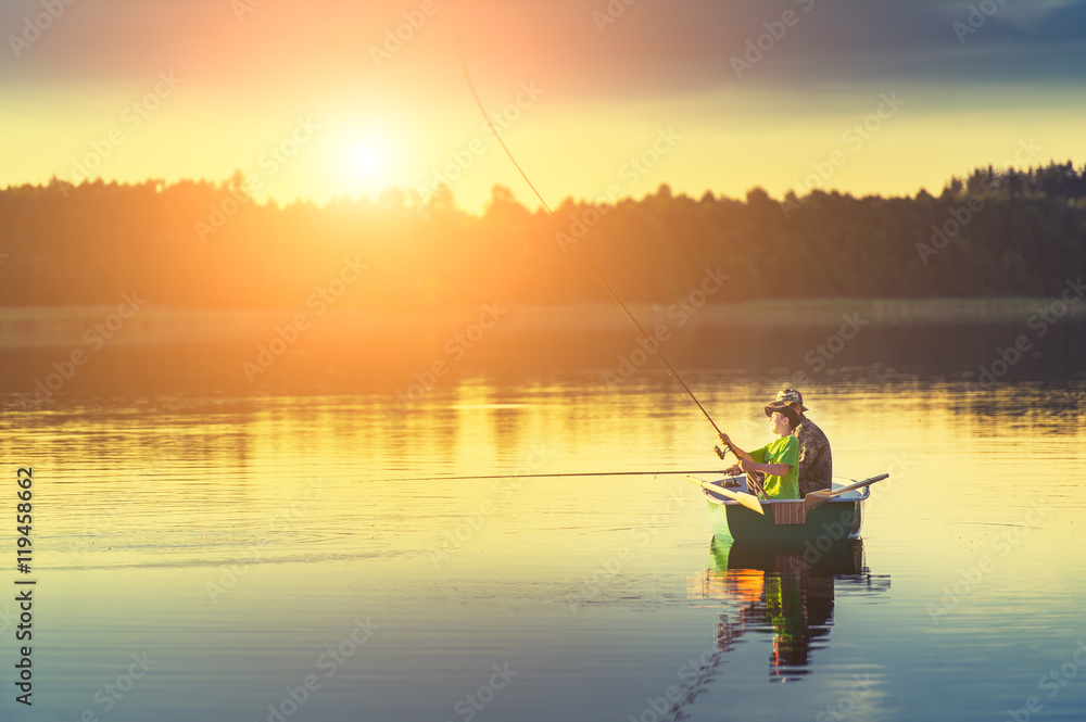 father and son catch fish from a boat at sunset father and son catch fish from a boat at sunset