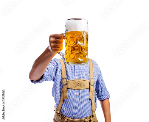 Man in traditional bavarian clothes holding mug of beer