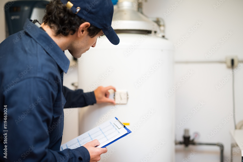 An Amarillo plumber reading a timer on a water heater