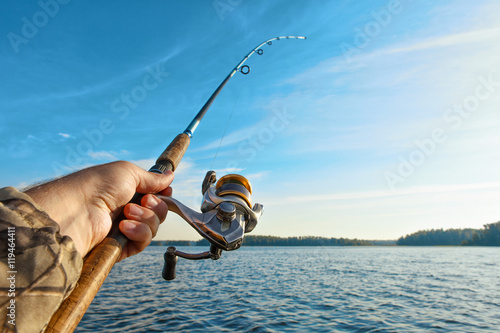 Leinwand Poster fishing on a lake at sunrise