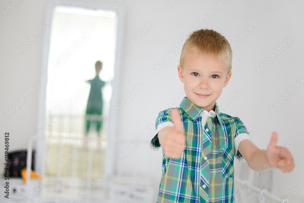 Little boy doing thumbs up for camera, standing at home Little boy doing thumbs up for camera, standing at home