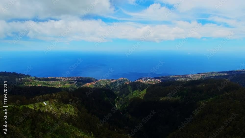 Portugal Madeira Funchal 4k travel aerial video background. Flight over mountain forest valley hills, village, ocean sea coast and blue sky clouds. Portugal Madeira Funchal 4k travel aerial video background. Flight over mountain forest valley hills, village, ocean sea coast and blue sky clouds.