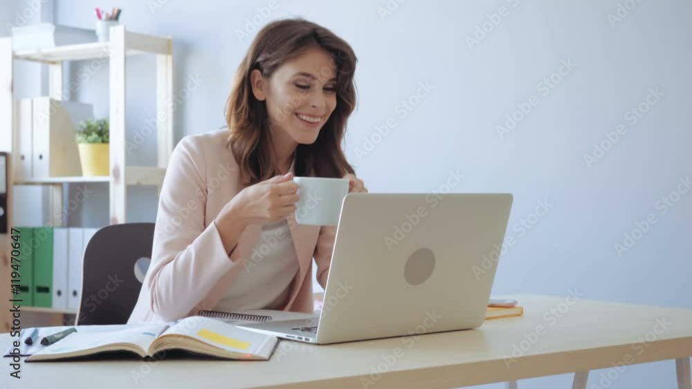 Business woman with drinking coffee, working on laptop at the office Business woman with drinking coffee, working on laptop at the office