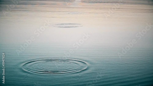 Stone skipping on water surface. Throwing a small flattened rock bouncing off water surface across body of water many times and finally sinking in the lake, river, sea or ocean