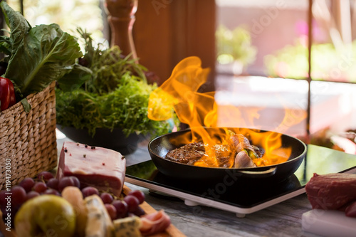 Flames in pan. Meat and garlic being fried. Recipe of flambe steak. Hot and spicy.